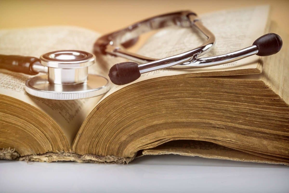 Stethoscope on an old book of medicine, conceptual image