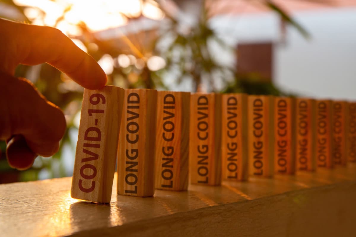 Hand poked on a row of wooden dominoes, with the words &#8222;COVID19&#8220;