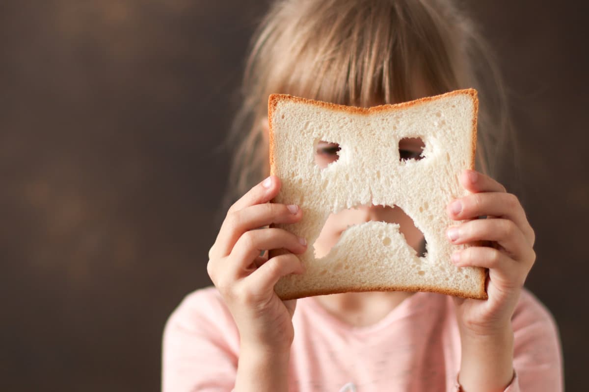 diet celiac gluten free sad bread in the hands of a child. Gluten free concept