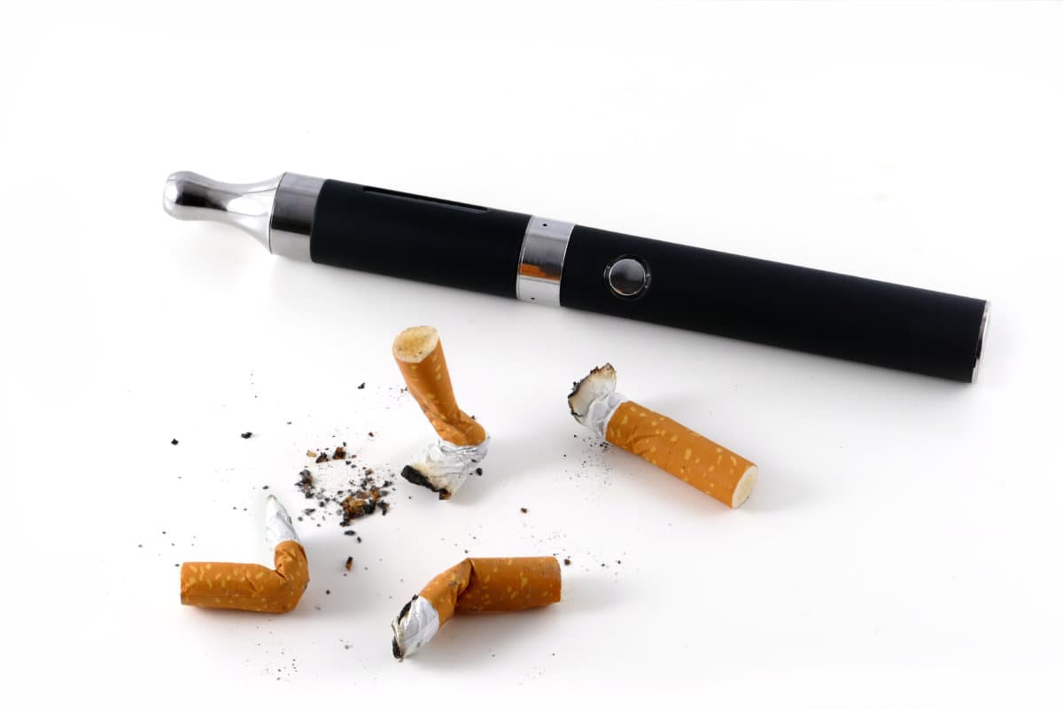 e-cigarette and cigarette butts isolated on white background, vaping against smoking