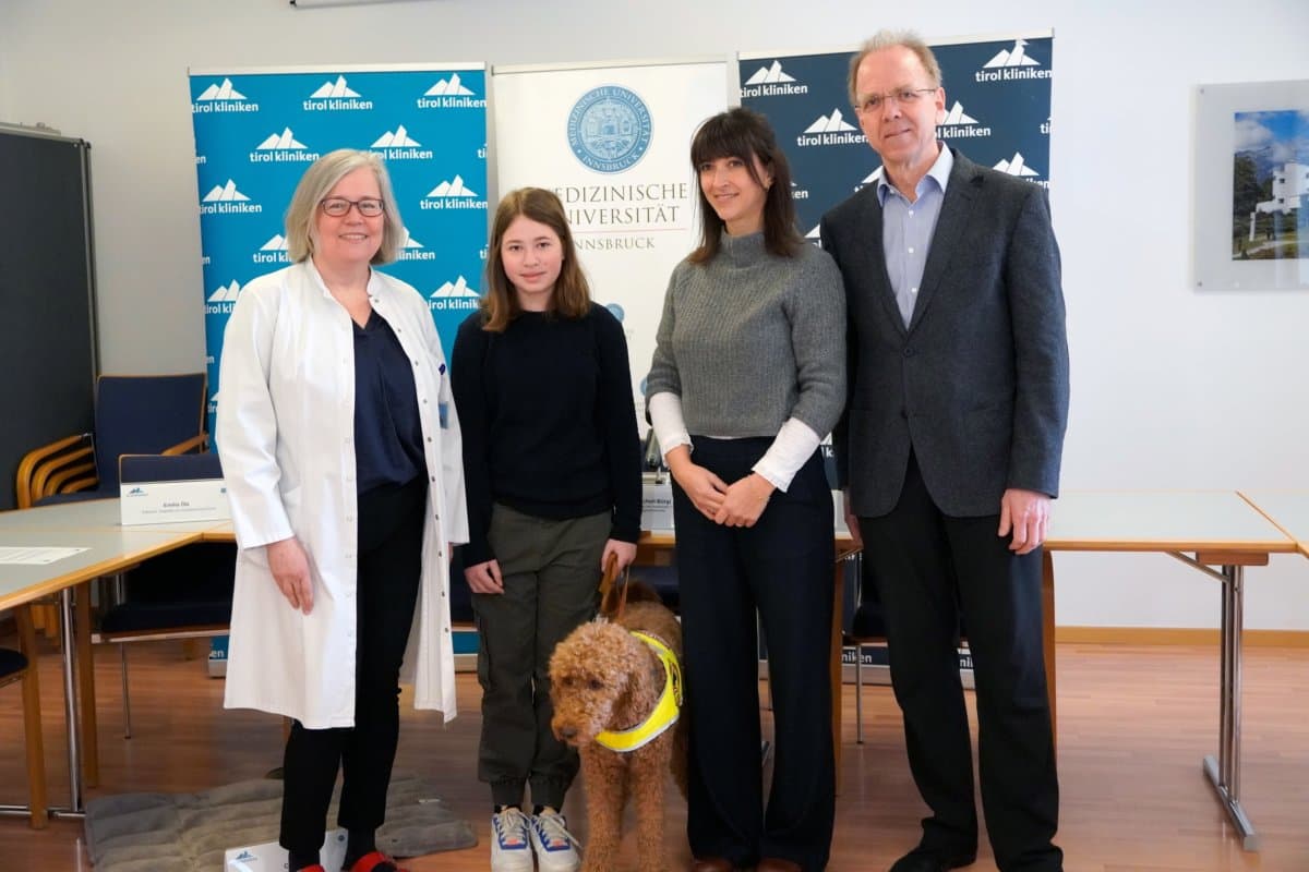 Zwei Frauen, ein Kind und ein Assistenzhund stehend