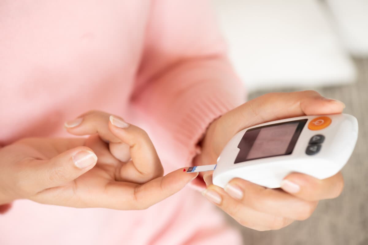 Nahaufnahme von Frauenhänden, die den Blutzuckerspiegel von Glucose Me überprüfen