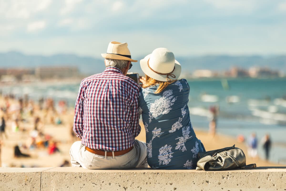 Loving the elderly couple sitting on the wall facing the beach,