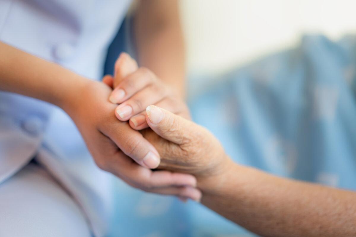 Krankenschwester sitzt auf einem Krankenhausbett neben einer älteren Frau, die mit den helfenden Händen hilft, Konzept der