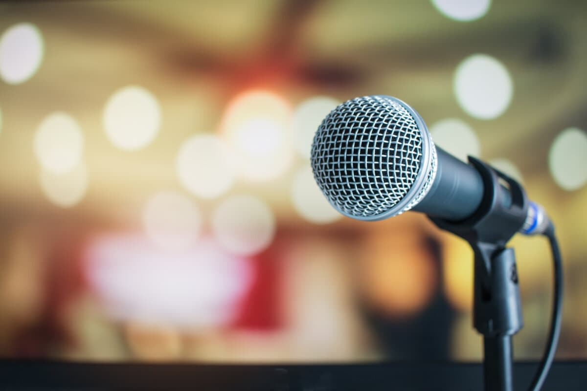 Mikrofon auf abstrakter, verschwommener Sprachaufnahme im Seminarraum oder im Konferenzsaal mit hellem Hintergrund