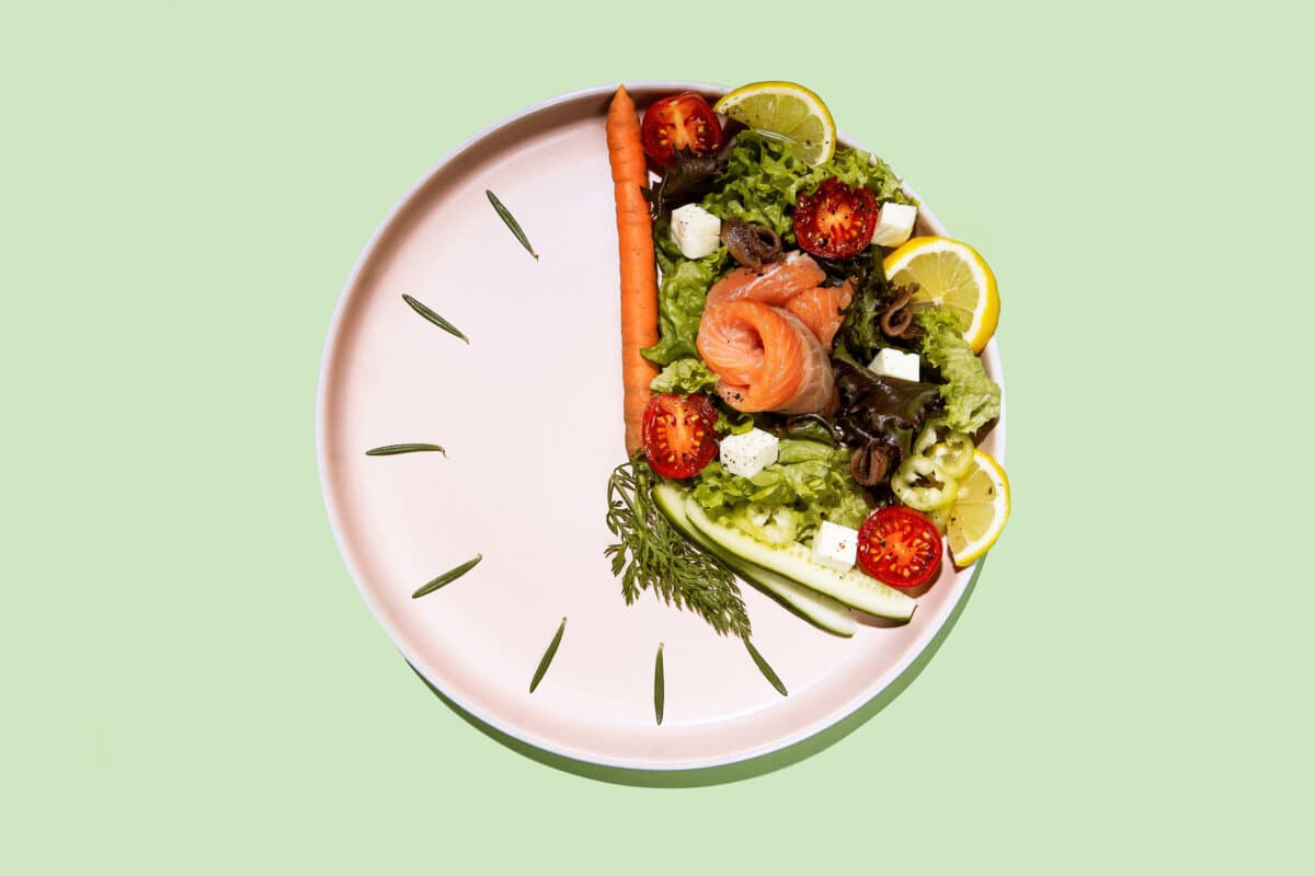 intermittent fasting concept plate as a clock with salad, salmon