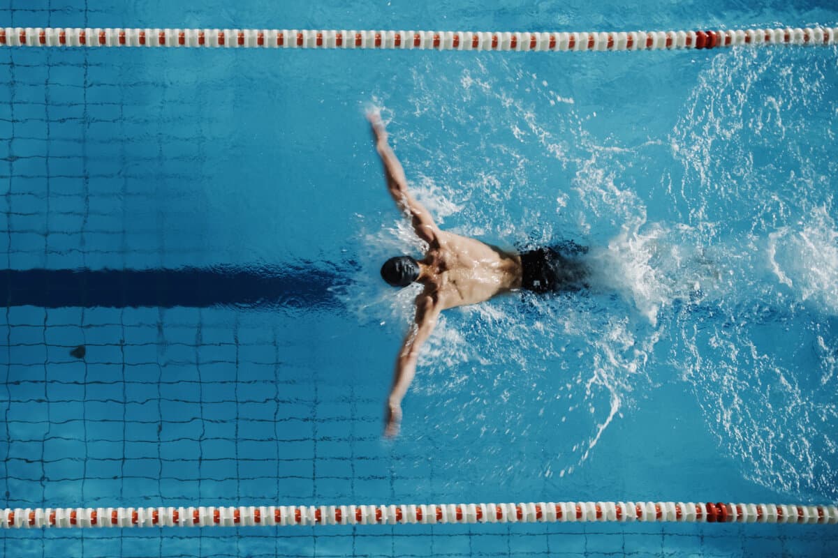 Luftaufnahme von oben, männlicher Schwimmer, der im Schwimmbad schwimmt. Professi
