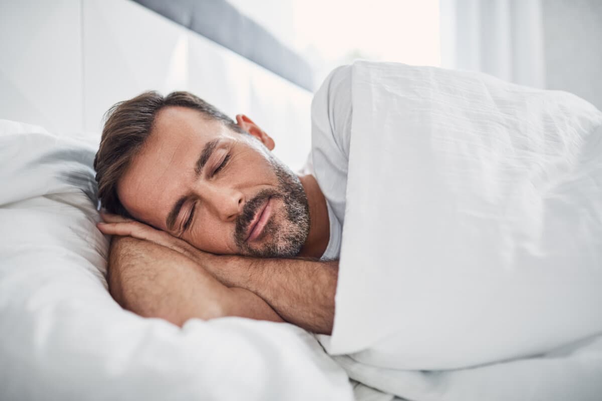 Konzept der Ruhe Schöner Mann schläft im Bett