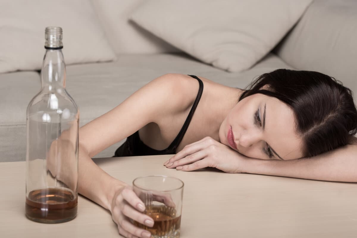 Junge, schöne Frau mit Depressionen trinkt Alkohol.