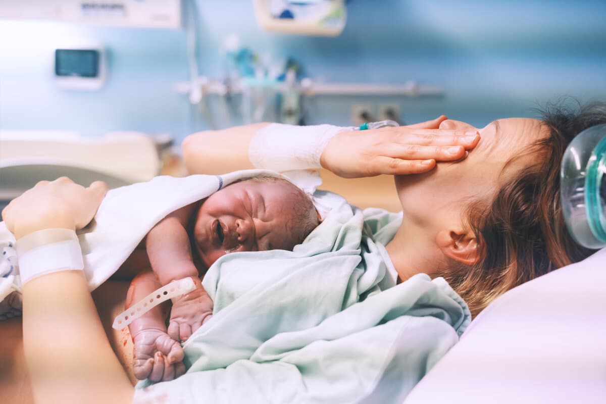 Mutter und Neugeborenes. Geburt eines Kindes im Entbindungsheim. Junge Mutter