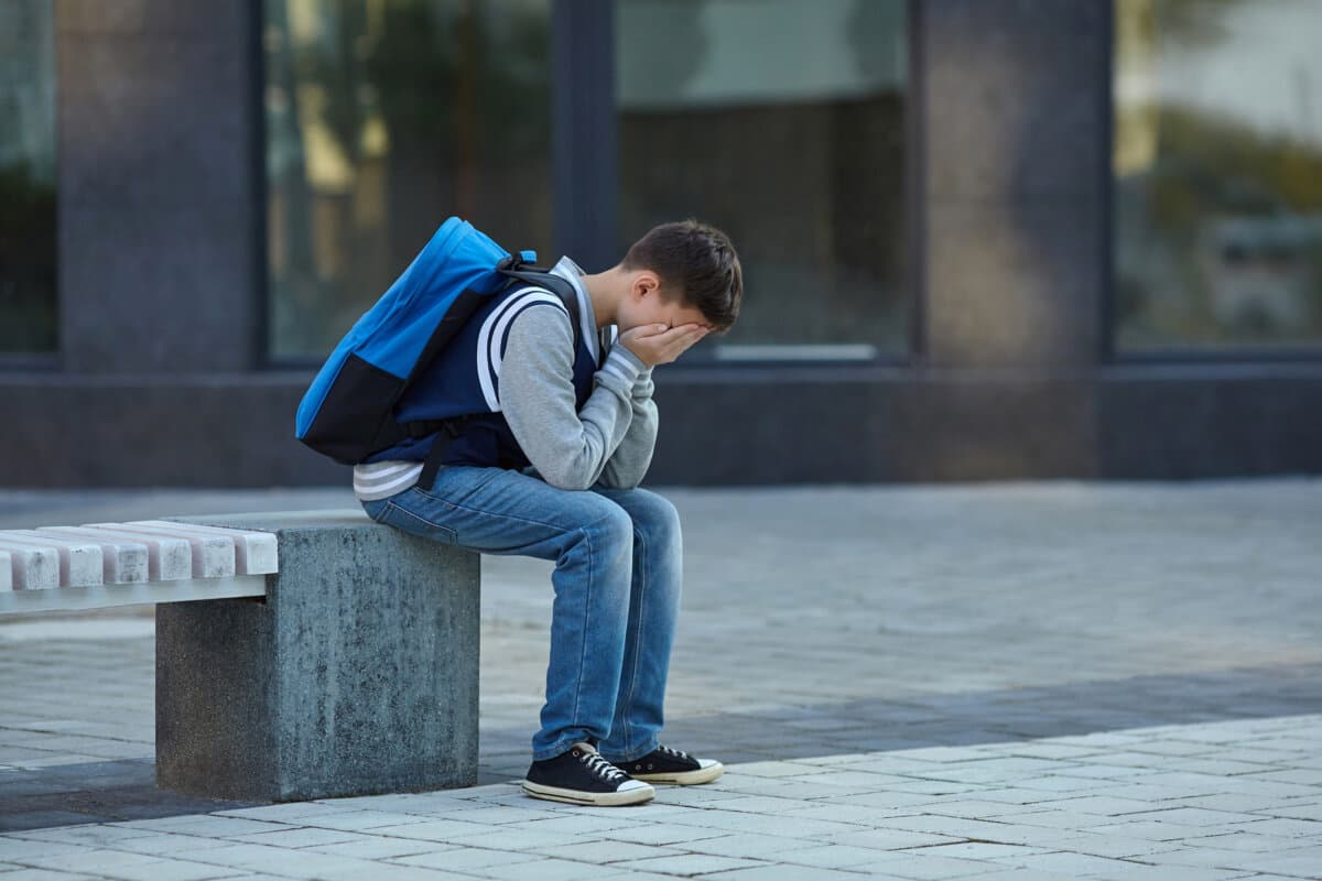 Schuljunge weint auf dem Schulhof. Negative Emotionen.