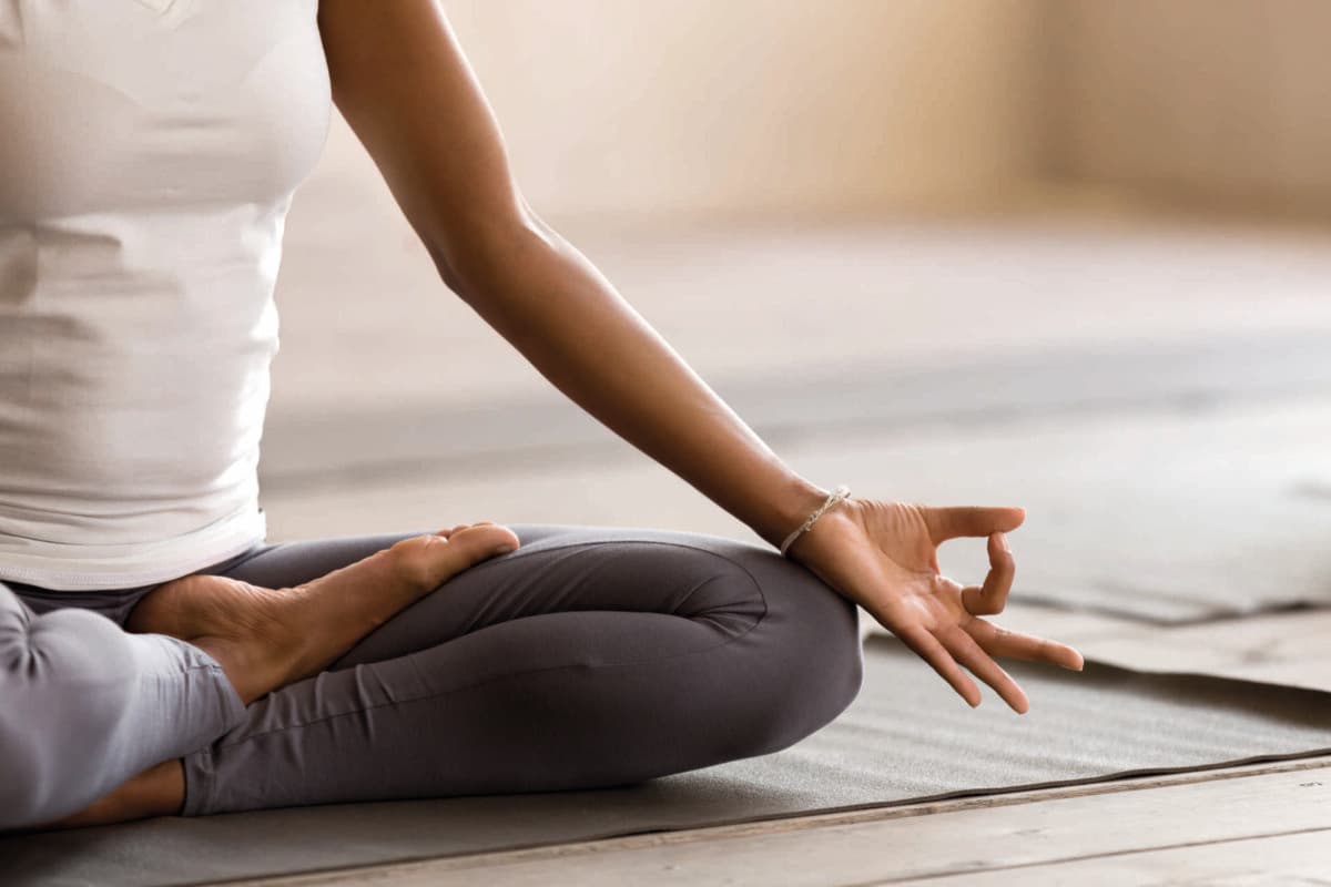 Schwarze Yogi-Frau praktiziert Yoga-Unterricht, macht Ardha Padmasana e