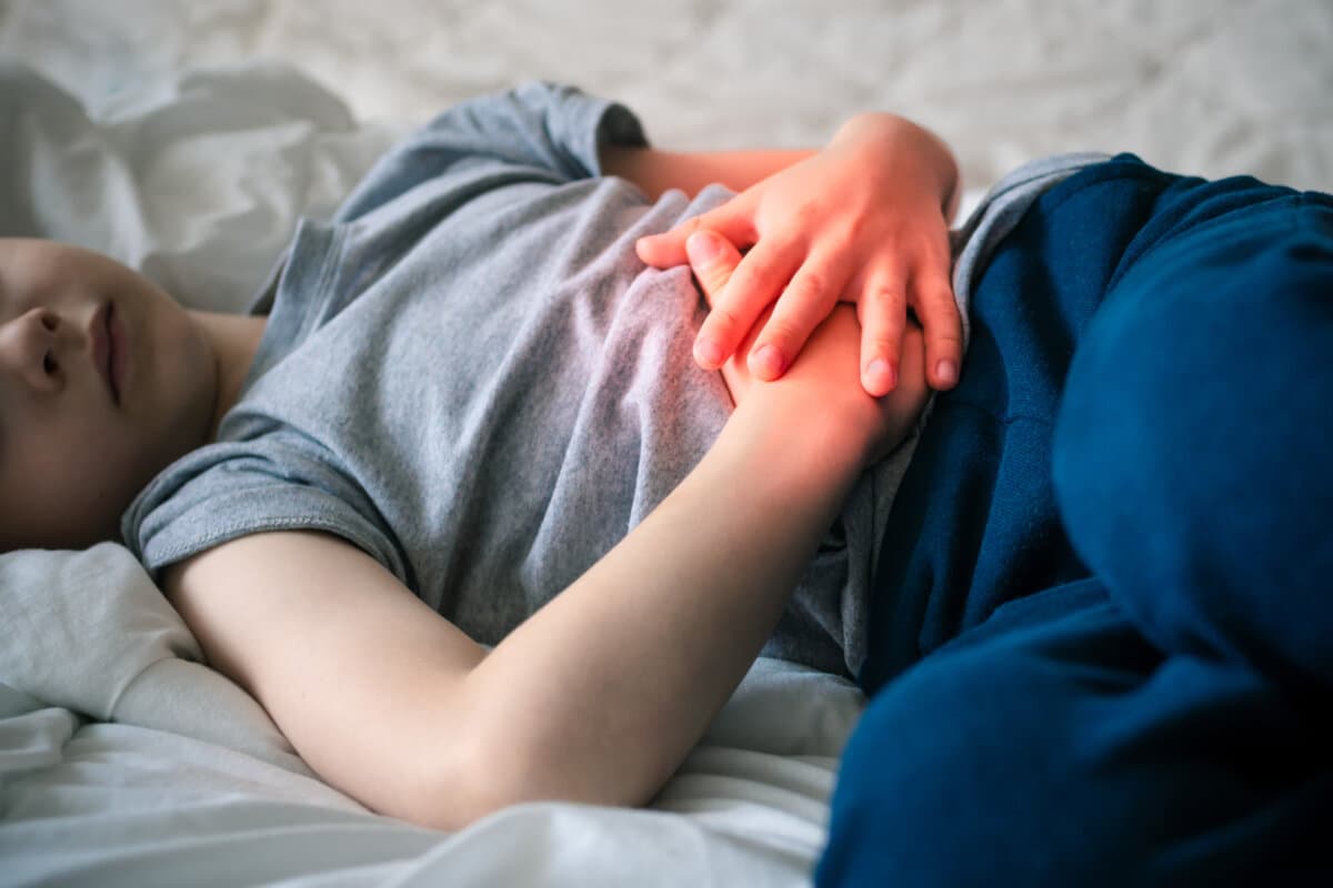 Bauchschmerzen bei einem Vorschulkind. Vergiftung bei Kindern. Der Junge hält seine Hände an die Bauchhöhle