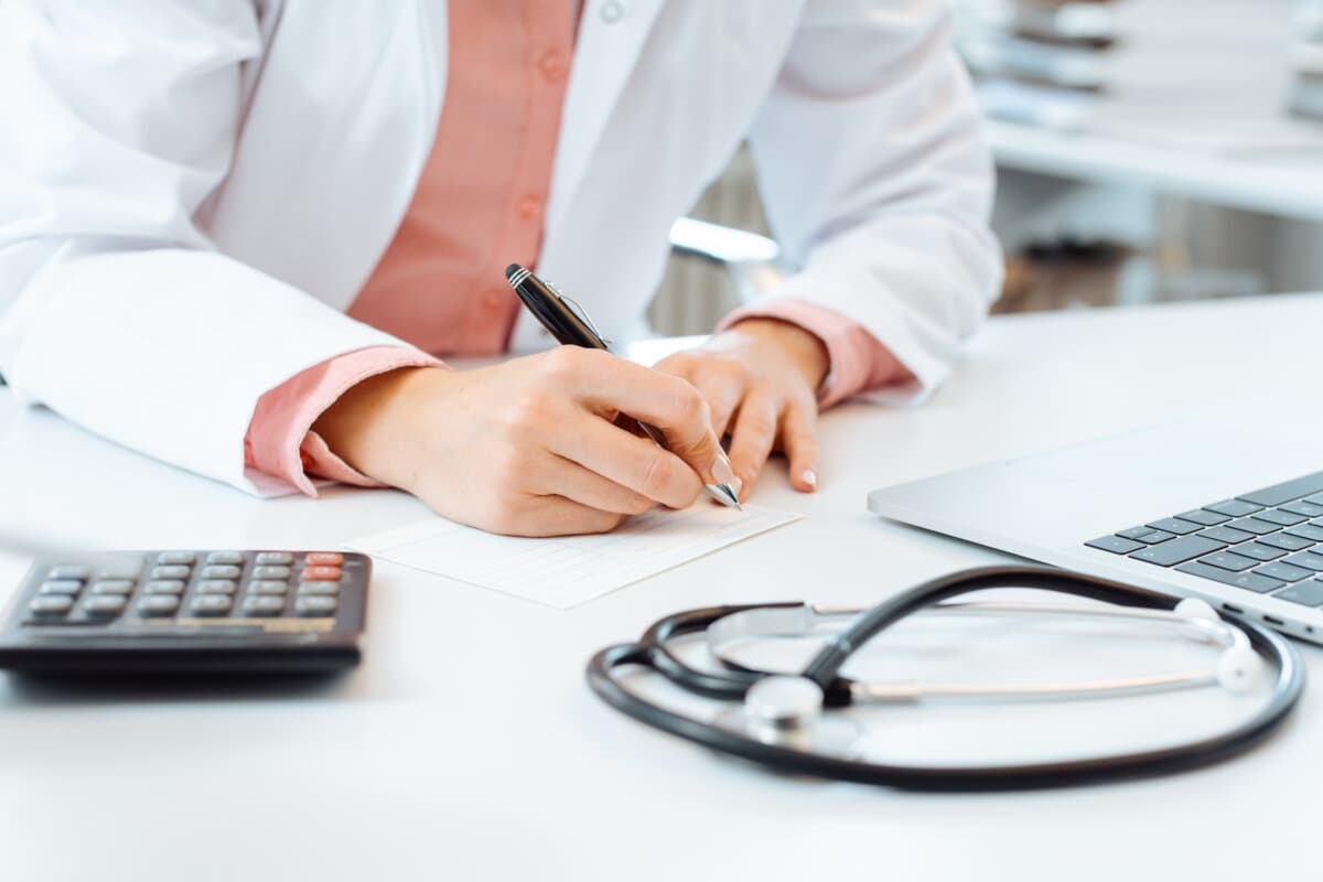 Die Ärztin schreibt ein Rezept auf ihren Schreibtisch