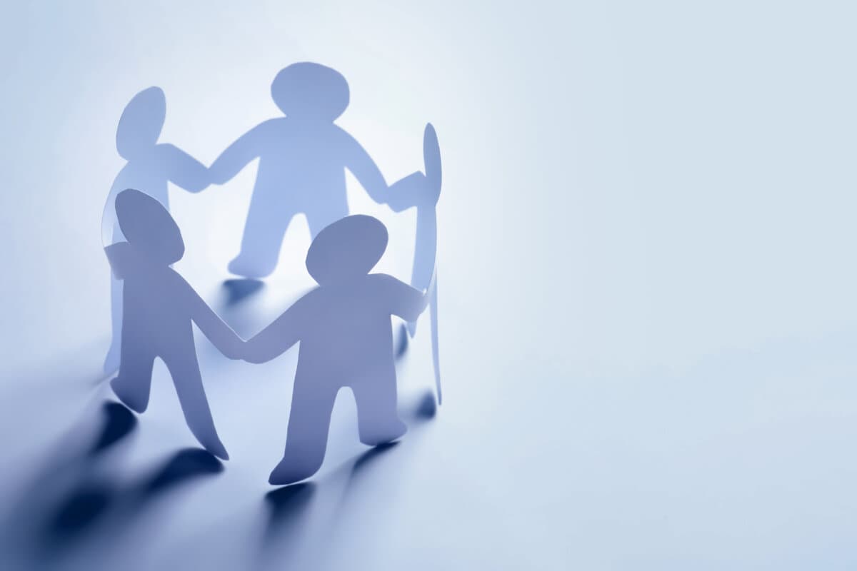 Personnages en papier se tenant la main sur fond clair. Concept Unity