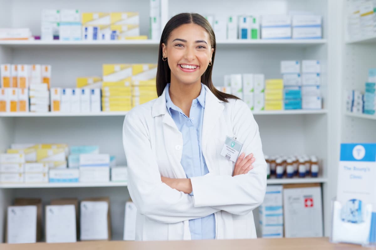 Porträt eines gut gelaunten und freundlichen Apothekers, der in einer Apotheke mit einem Tablet den Lagerbestand oder