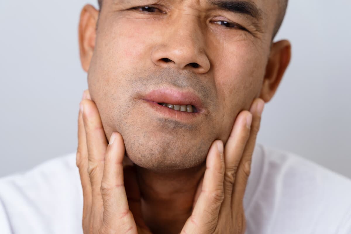 Man has facial swelling due to an allergic reaction to triggers such as insect bites, food