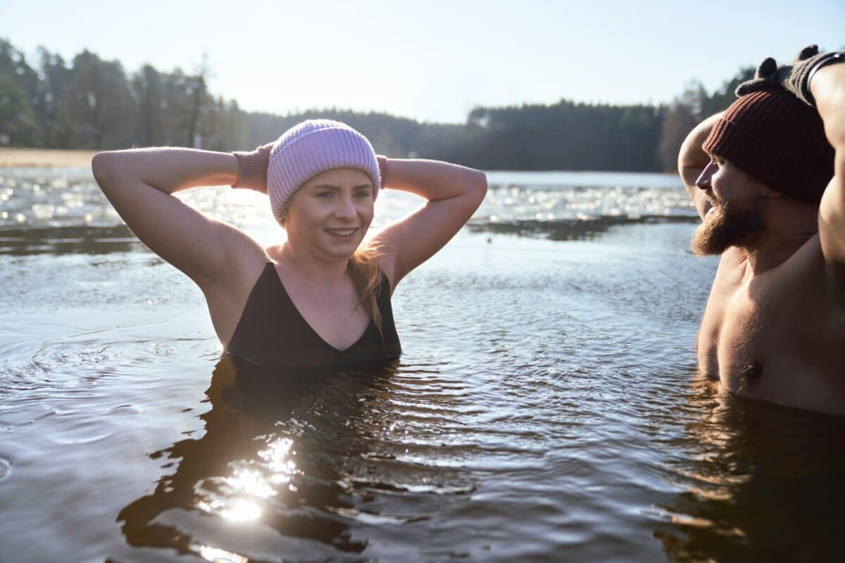 Zwei Menschen beim Eisbaden in einem zugefrorenen See