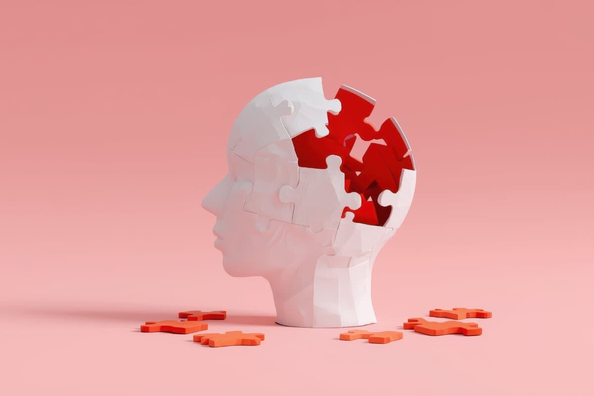 Conceptual backdrop of brain health related to dementia and Alzheimer’s, featuring a paper head with puzzle pieces on