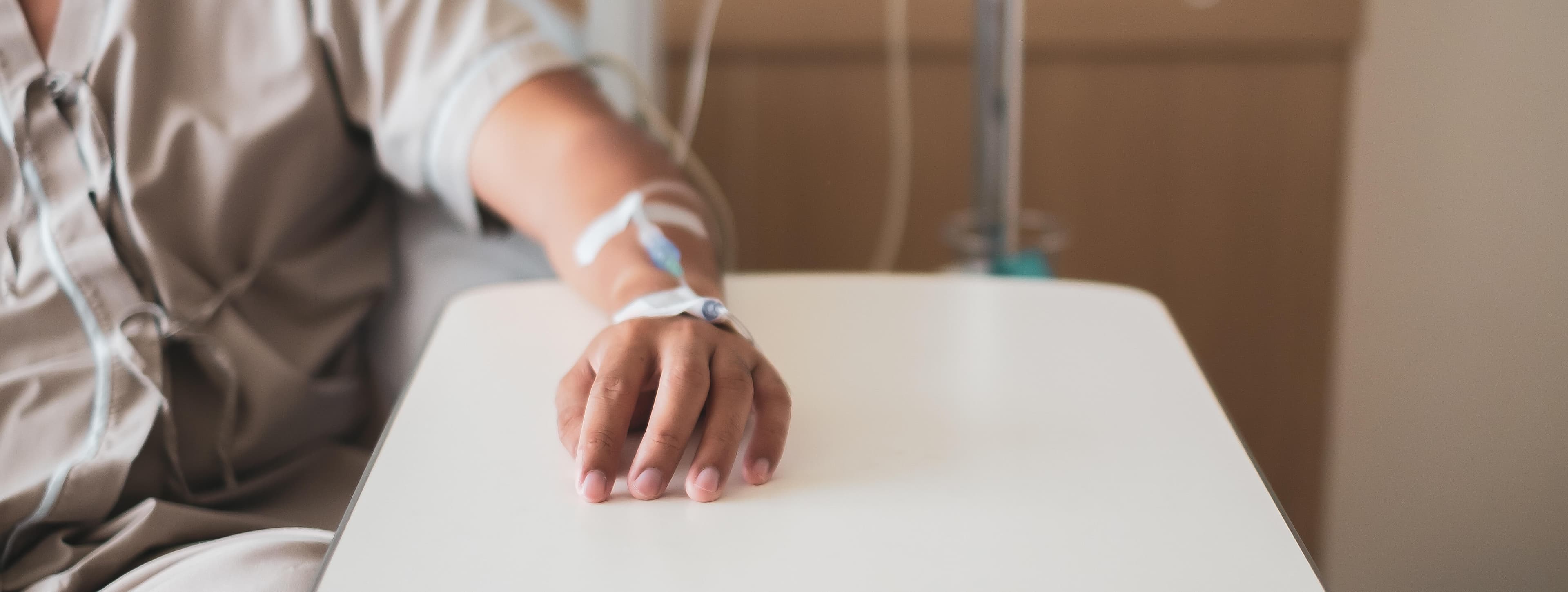 Calm patient got medicine injection on left hand during admission and medical operation in hospital.