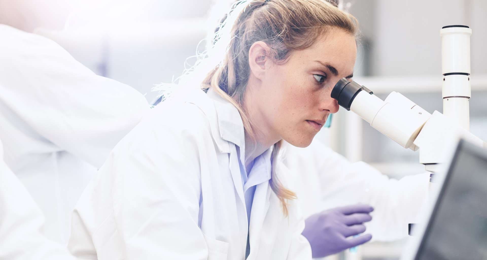 Wissenschaftler, der in das Mikroskop schaut