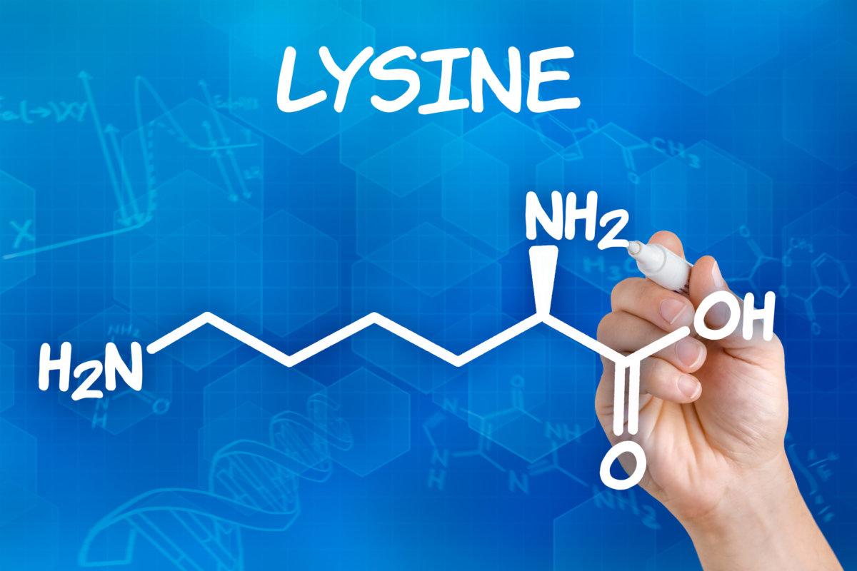 Hand mit Stift zeichnet die chemische Formel von Lysin