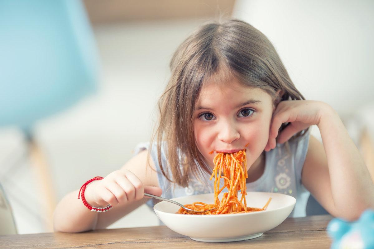 Niedliches kleines Mädchen, das zu Hause Spaghetti Bolognese isst.