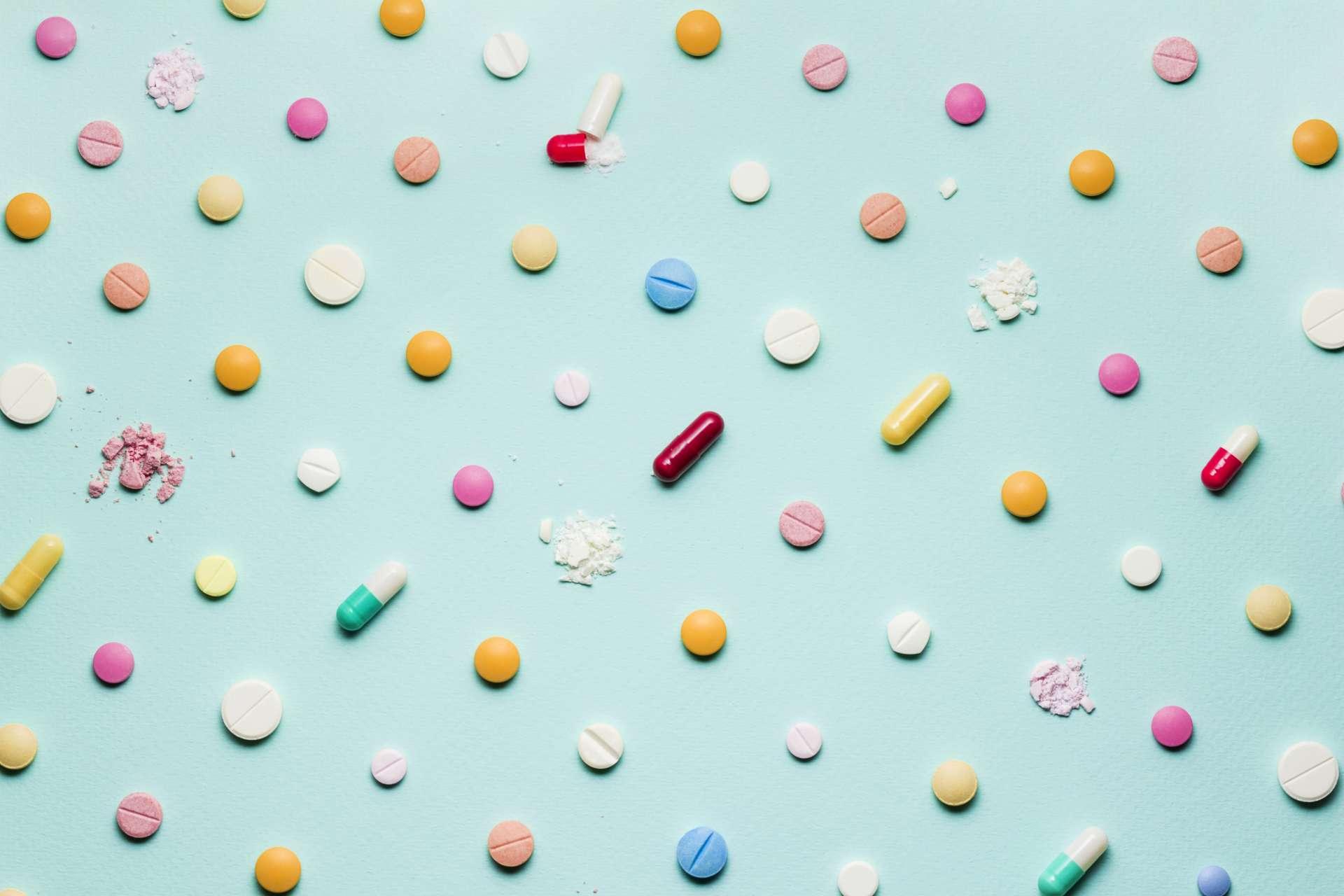 Ein Foto von verschiedenen Arzneimitteln, Tabletten und Pillen auf blauem Hintergrund.