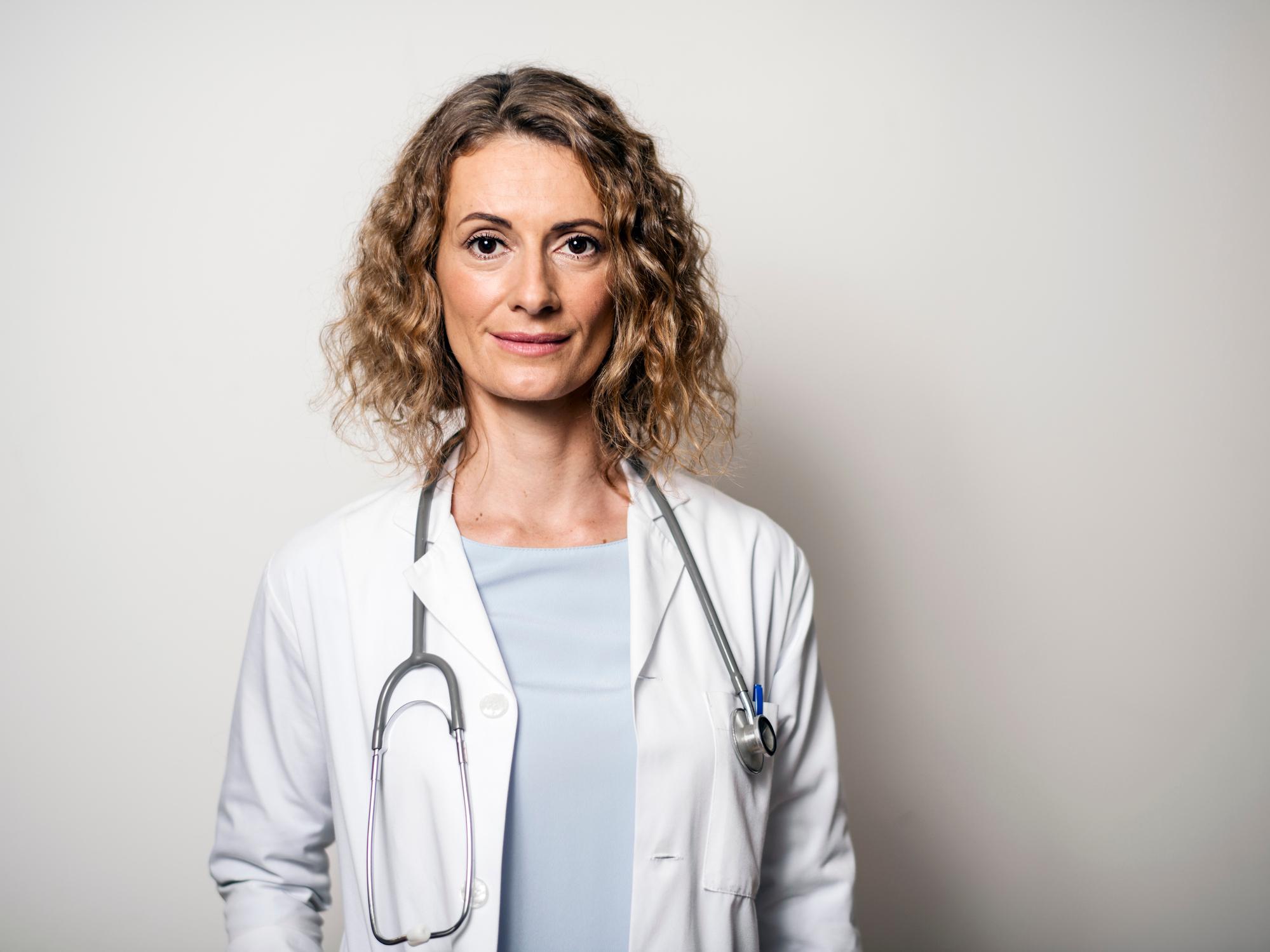 Porträt der Ärztin gegen Wand im Krankenhaus