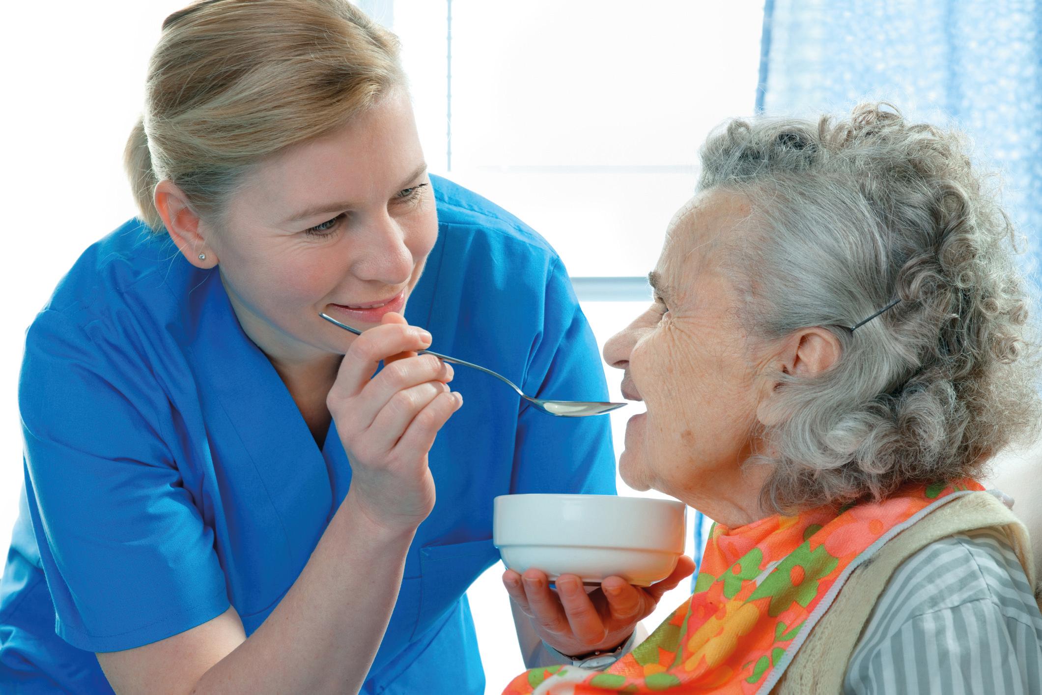 ältere Frau 90 Jahre alt, die von einer Krankenschwester gefüttert wird