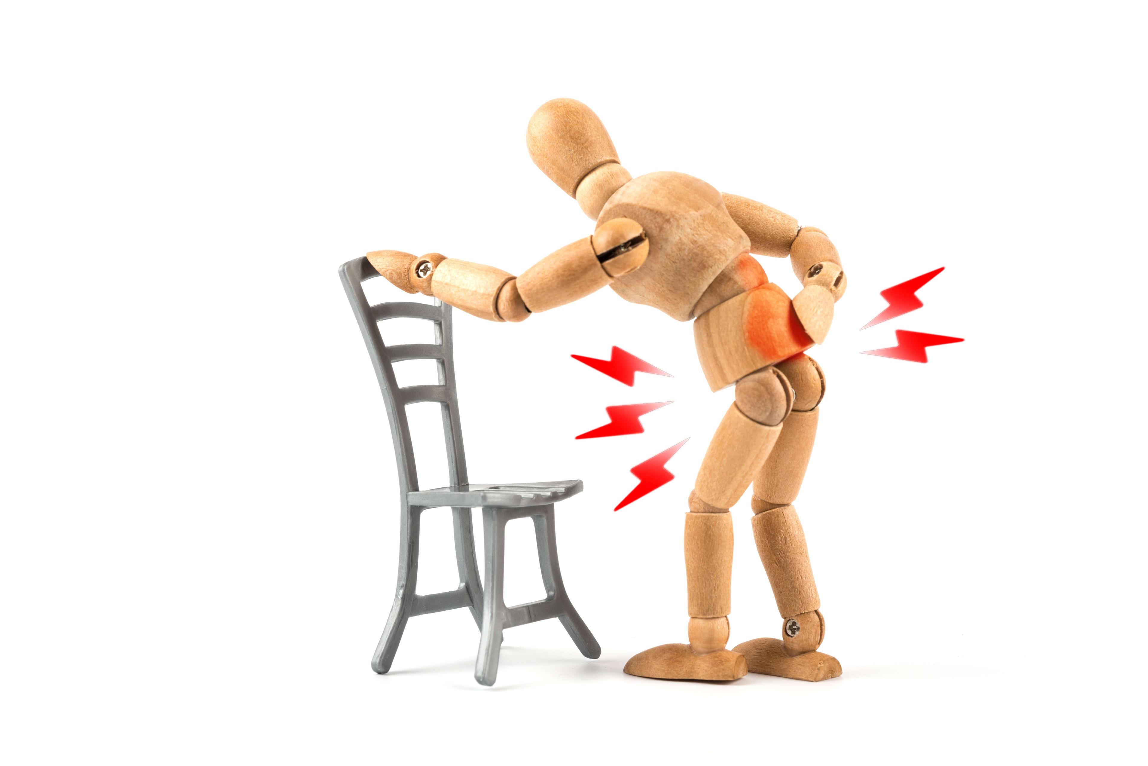 Holzpuppe hat Rückenschmerzen durch falsches Sitzen oder Stehen