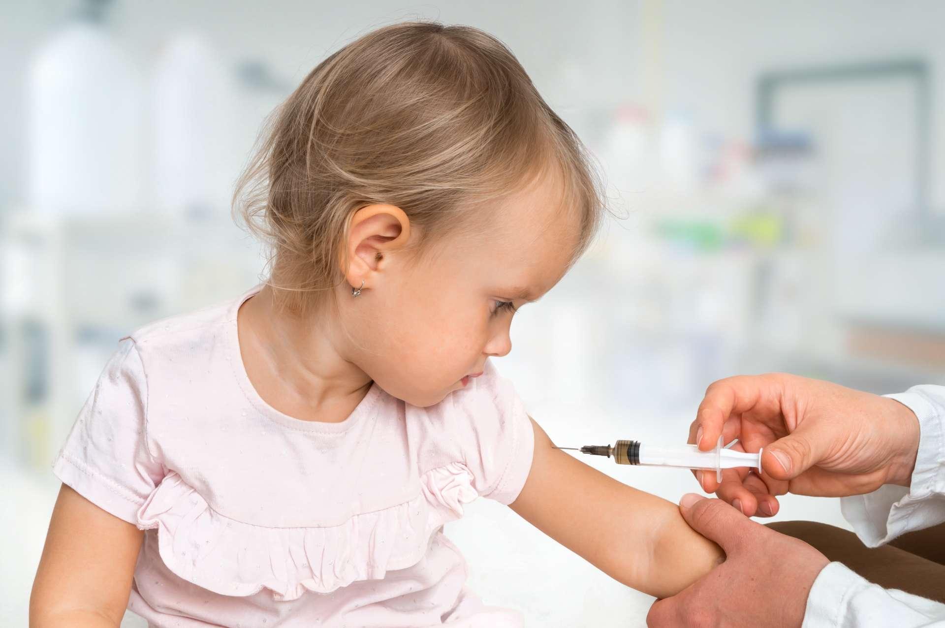 Kinderarzt injiziert Impfstoff in die Schulter des Babys - Impfkonzept