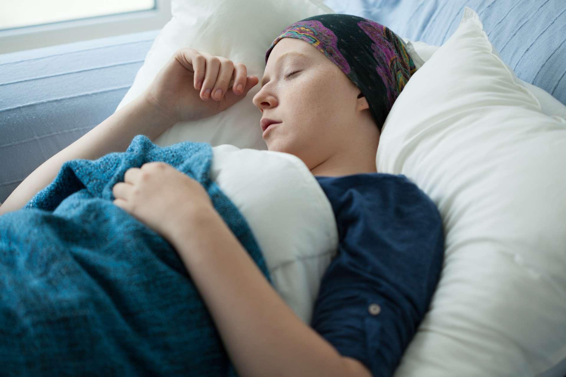 Frau mit Krebs, der im Bett ruht, horizontal