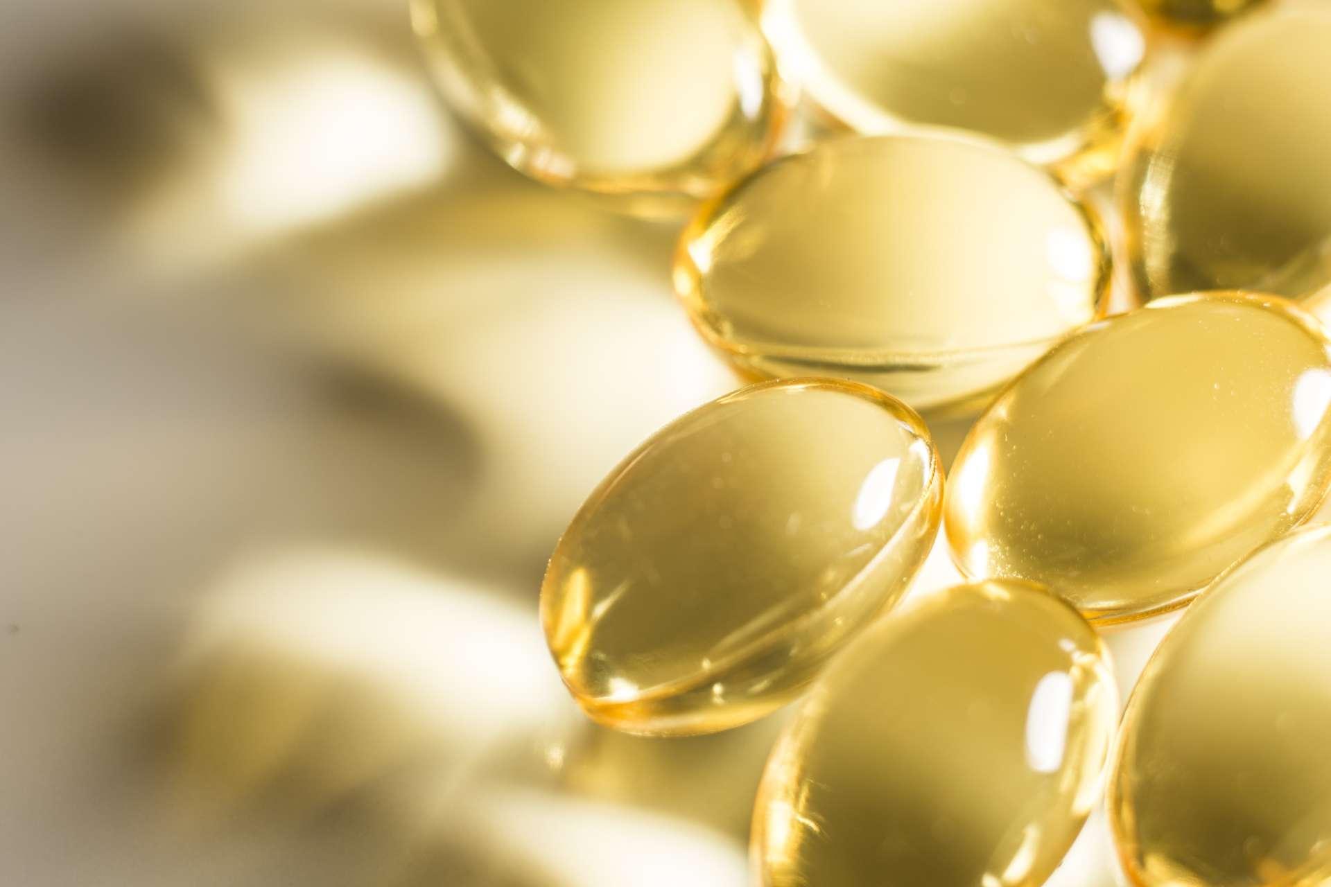 Omega 3 Fischöl transparente Tabletten beleuchtet auf weißer Oberfläche