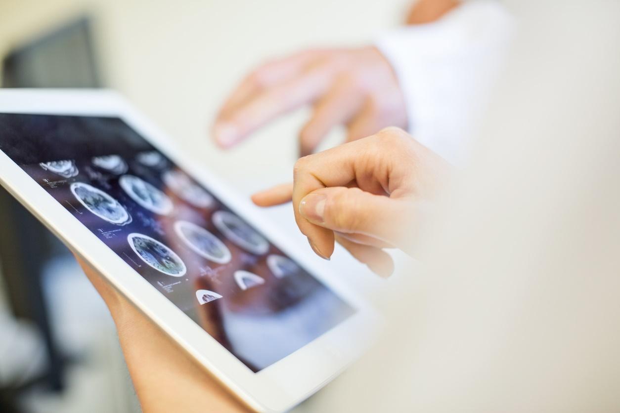 Medizinisches Team, das MRT-Scans auf einem digitalen Tablet analysiert