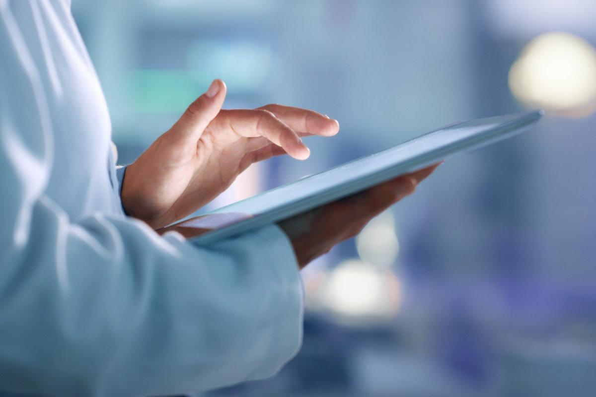 Ärzte, Forscher oder Wissenschaftler surfen auf einem Tablet im Internet nach Informationen, während sie in einem Labor, einer wissenschaftlichen Einrichtung oder einem Krankenhaus arbeiten. Experte, Mediziner oder Chirurg, der im Internet sucht