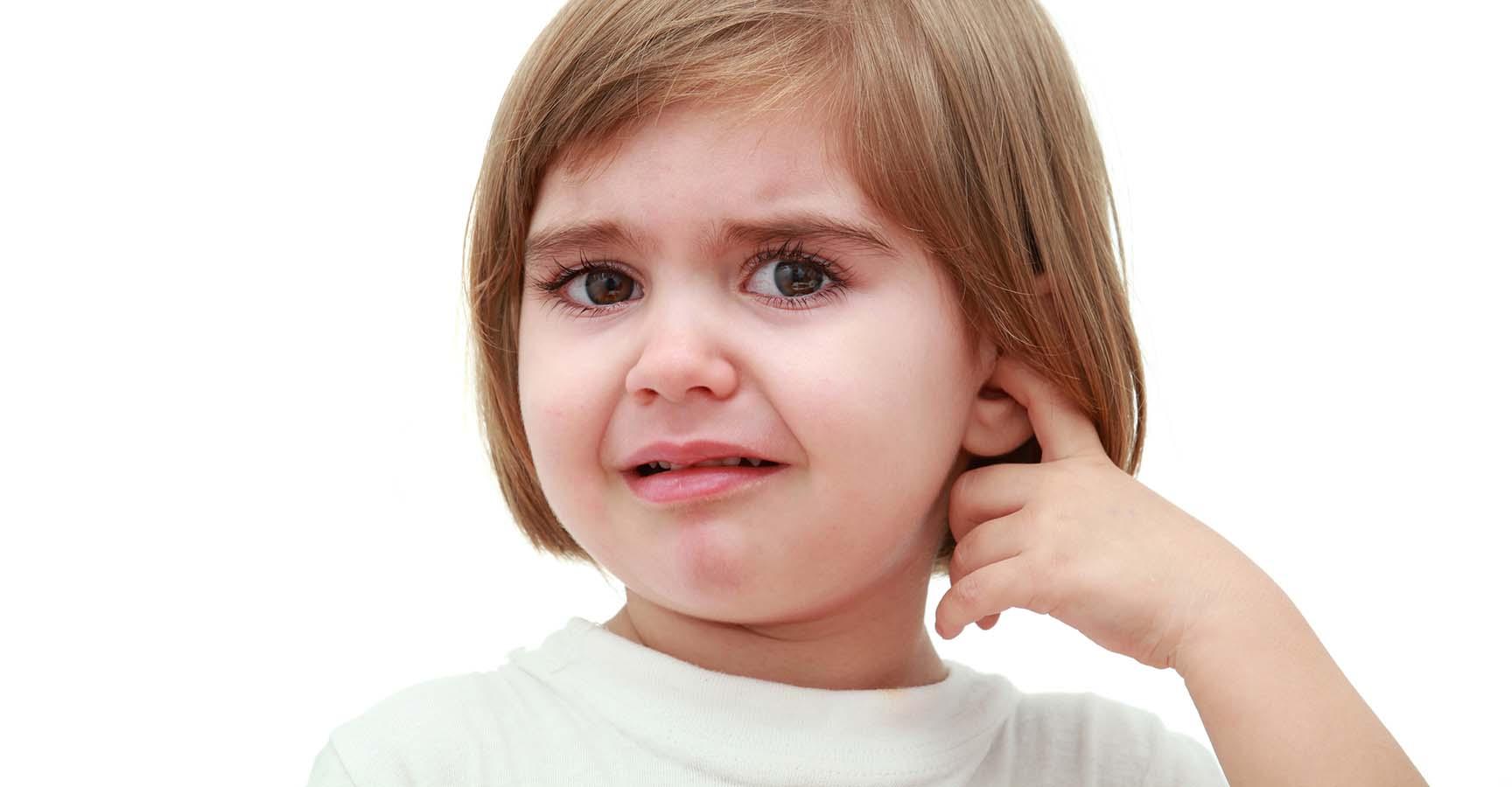 3 years old girl crying and holding a finger in the ear