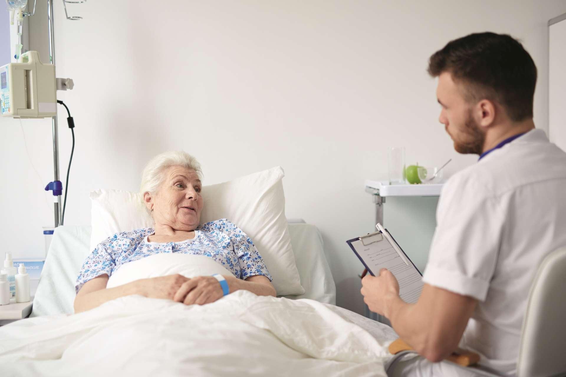 Ältere Frau Seniorin im Bett spricht mit ihrem Arzt