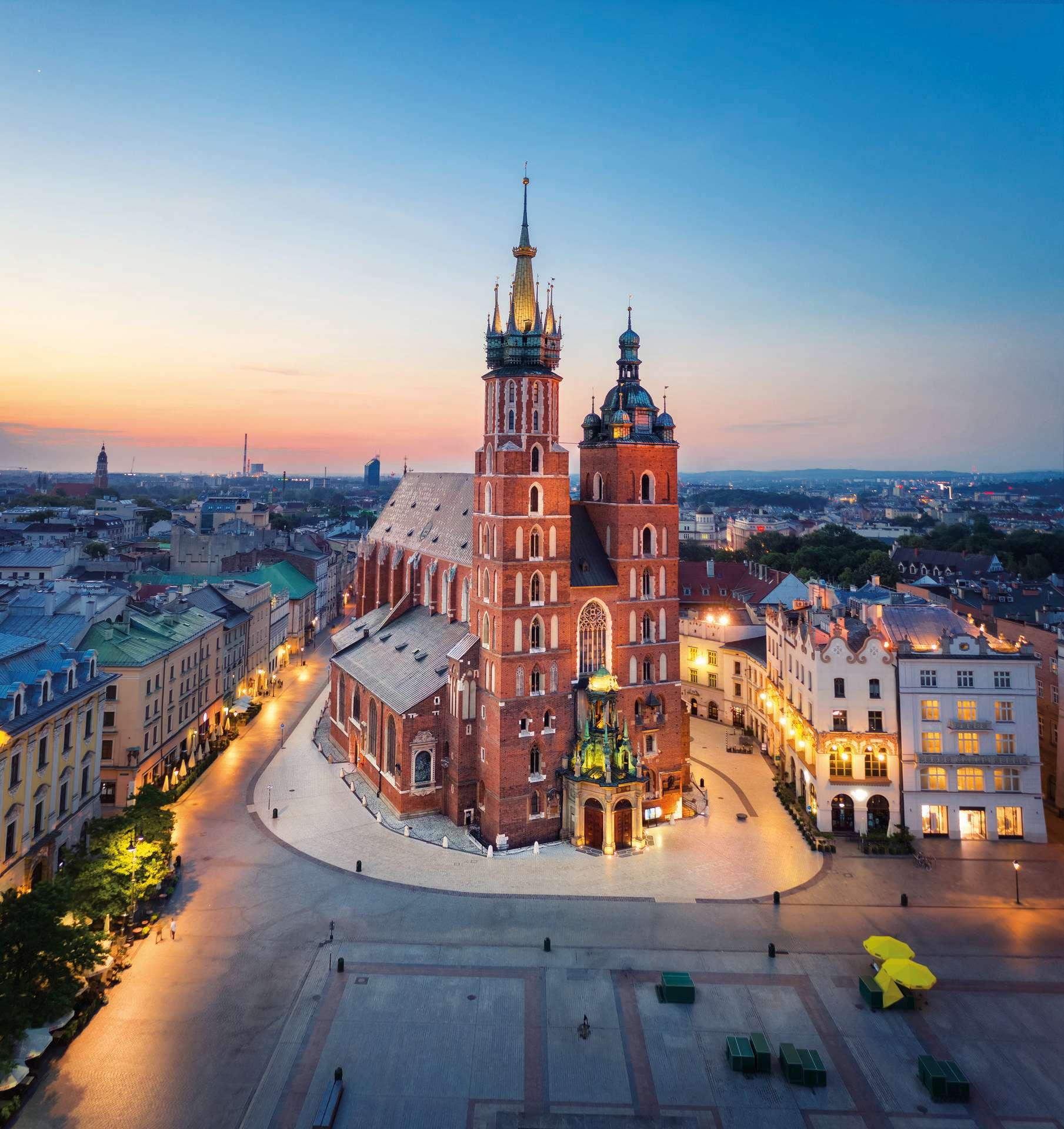 Krakau, Polen. Luftaufnahme der beleuchteten Marienbasilika (Bazylika Mariacka) bei Sonnenaufgang