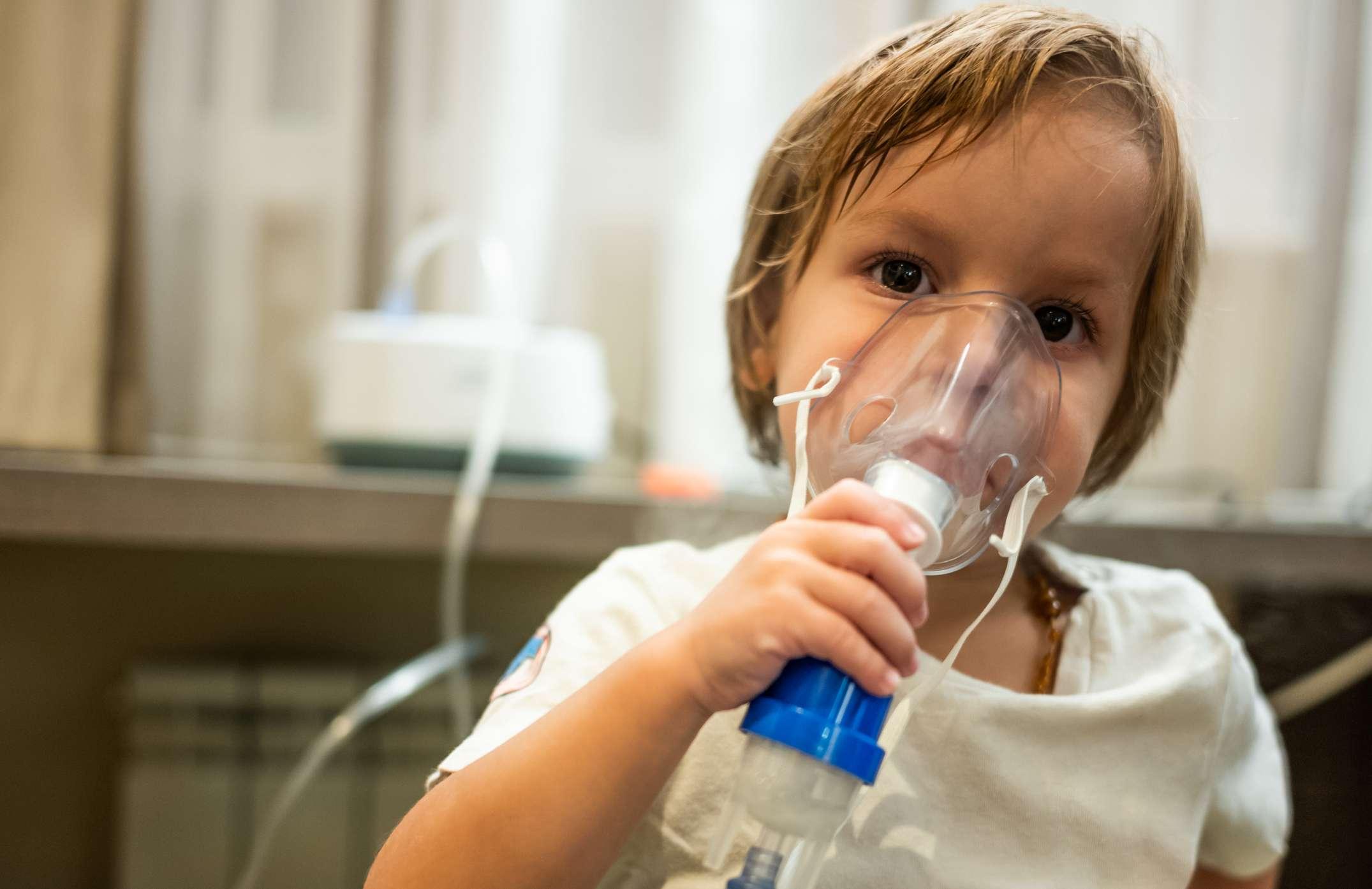 Kleines Kind, das Asthmabehandlung erhält und zu Hause einen Inhalator verwendet.