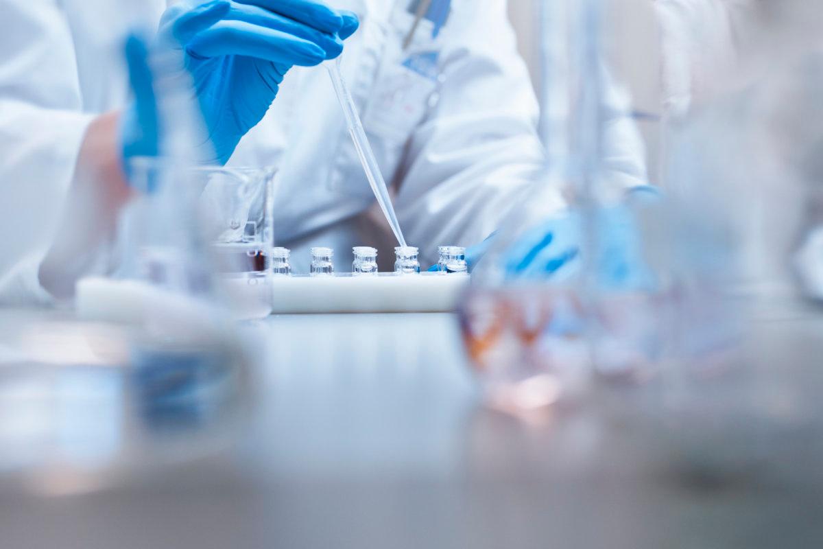 Chemiker füllt Fläschchen im Experiment im Labor