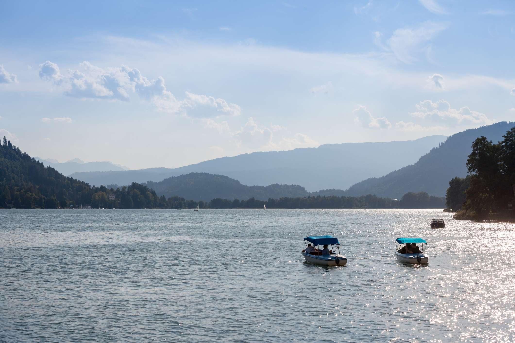 zwei elektrische miniboote am ossiacher see im sommer. Der Ossiachersee oder Ossiacher See ist ein Alpensee in der Nähe von Villach in Kärnten.
