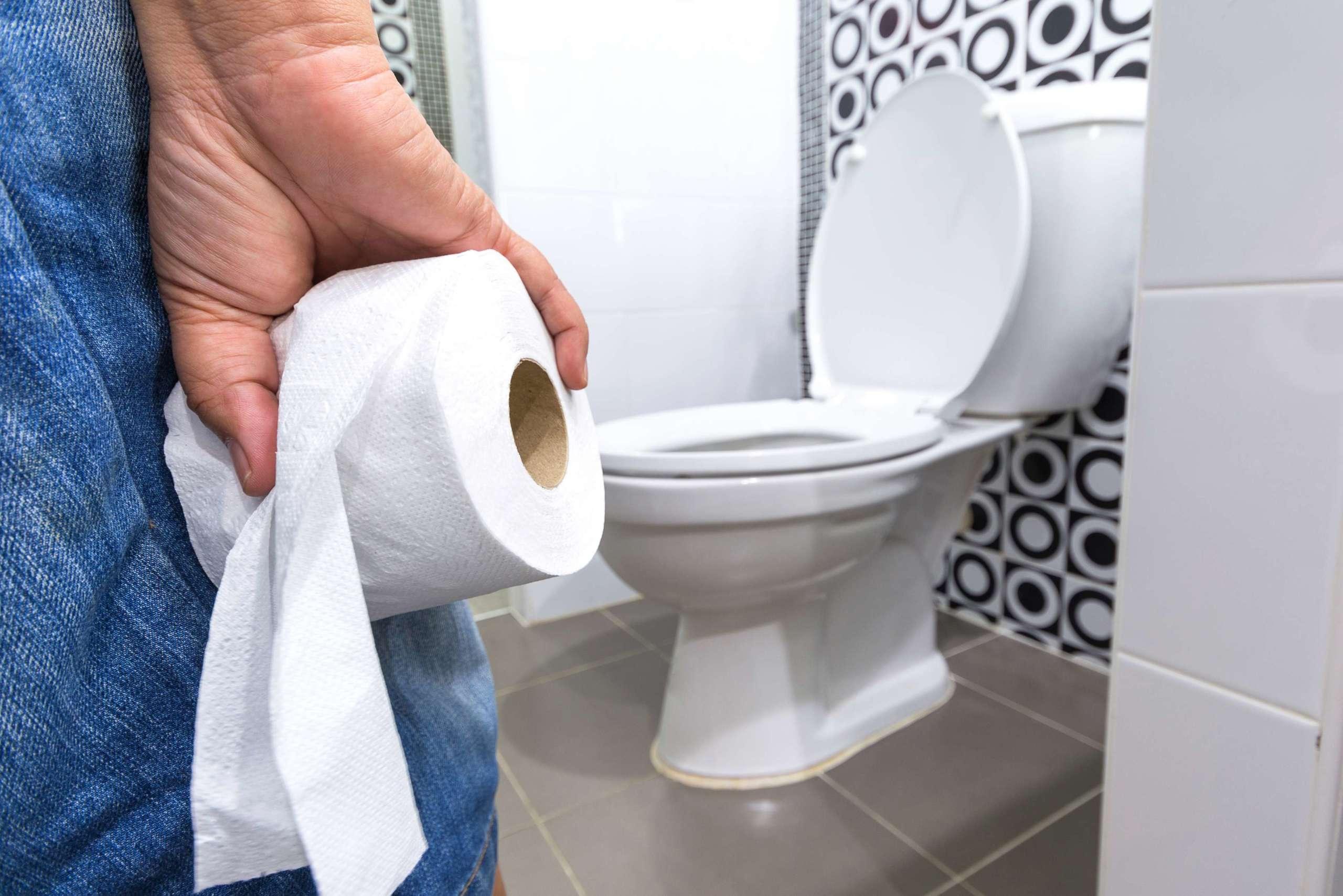 Hand hält Toilettenpapier.Durchfall Verstopfung.Gesundheitskonzept