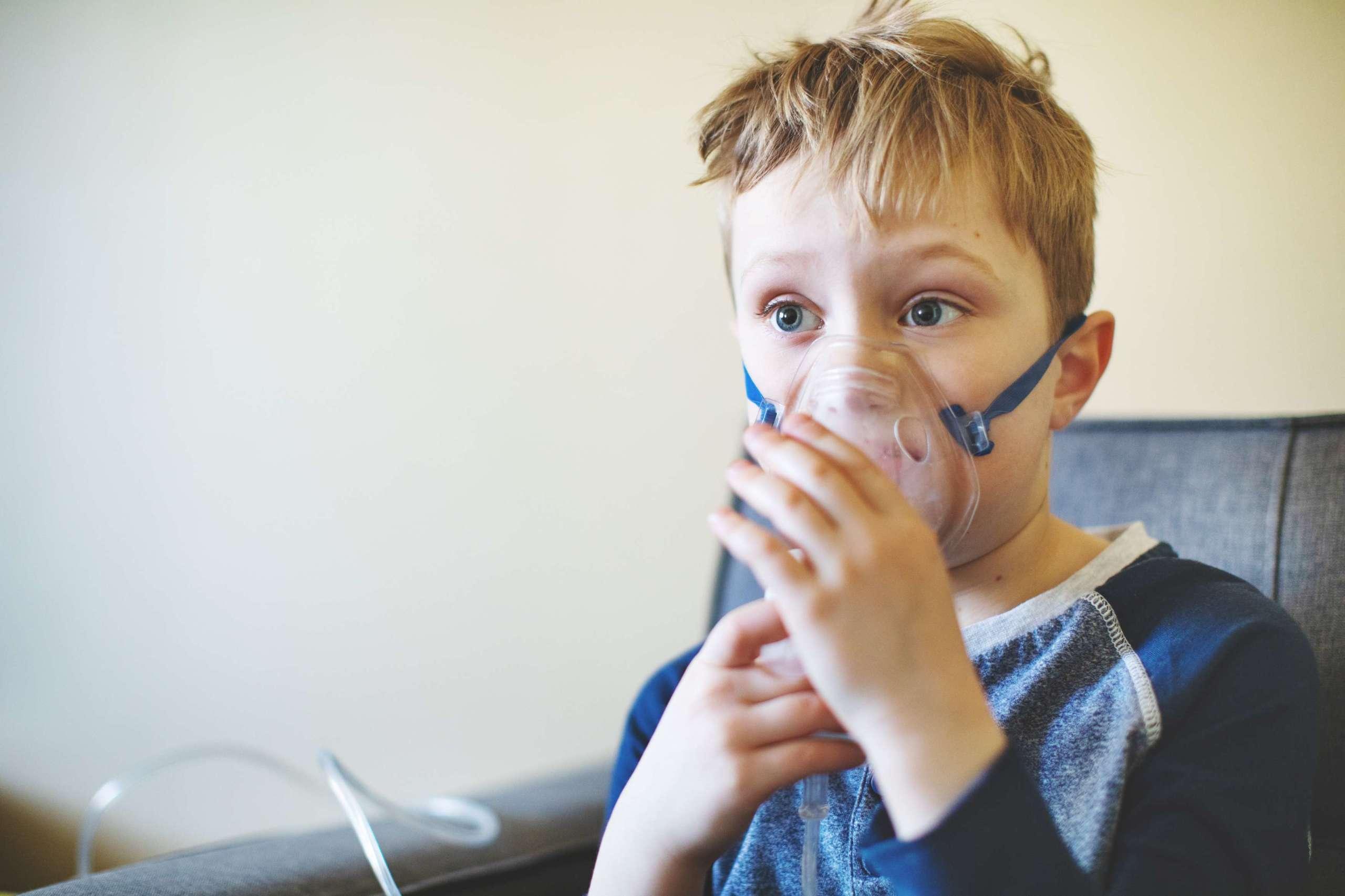 Kind mit Asthma-Inhalator zu Hause