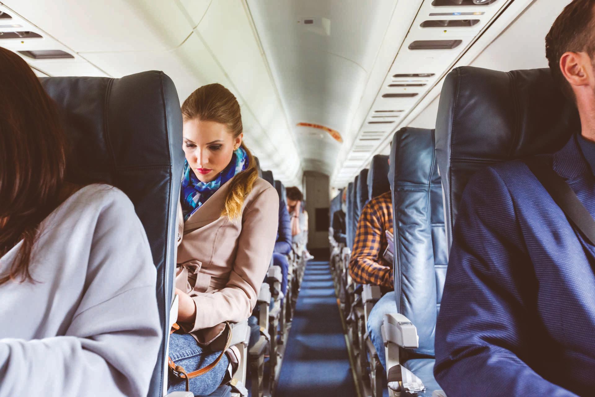 Innenraum eines Flugzeugs mit Menschen, die auf Sitzen sitzen. Passagiere auf dem Sitz während des Fluges.
