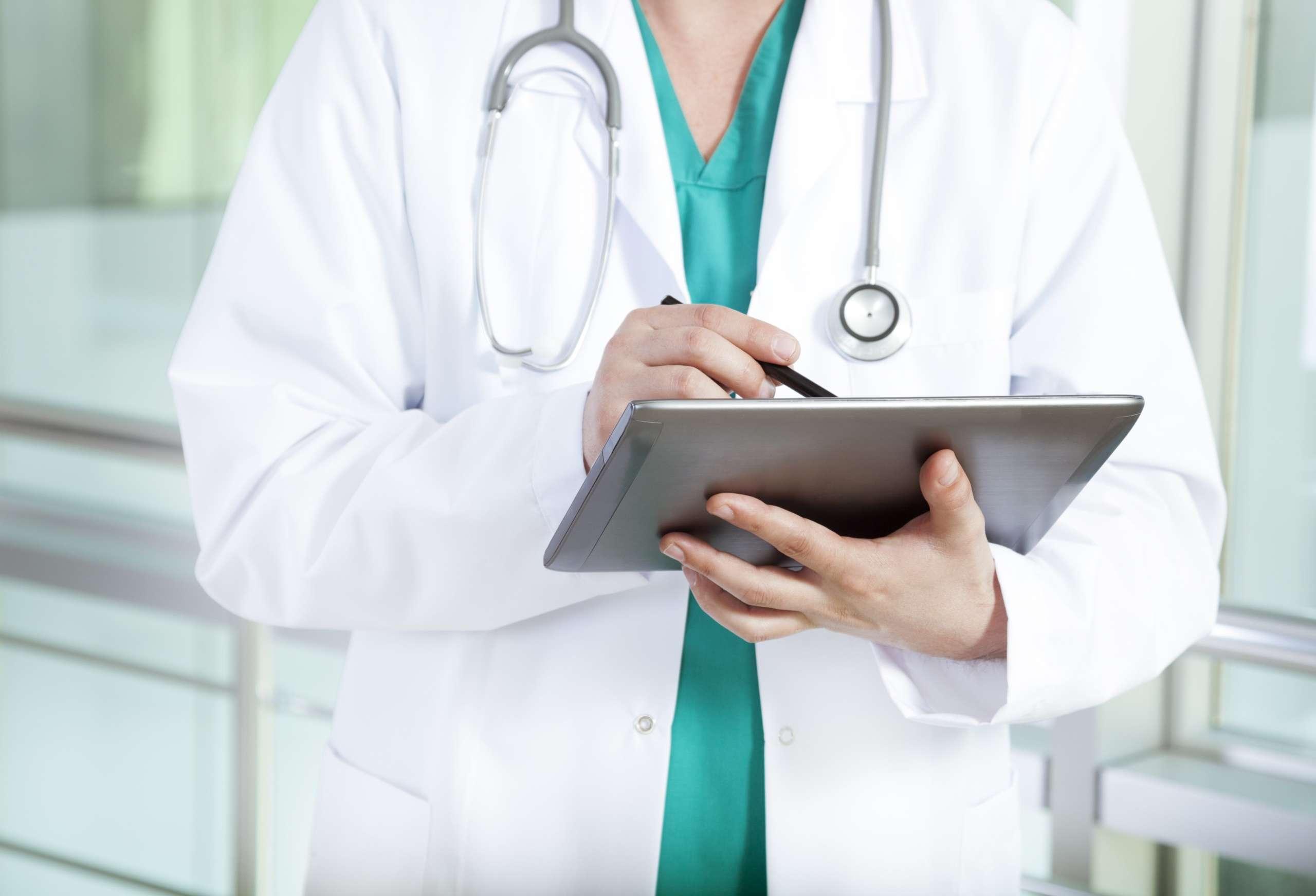 Arzt im Krankenhaus beim Schreiben digitaler Tablets
