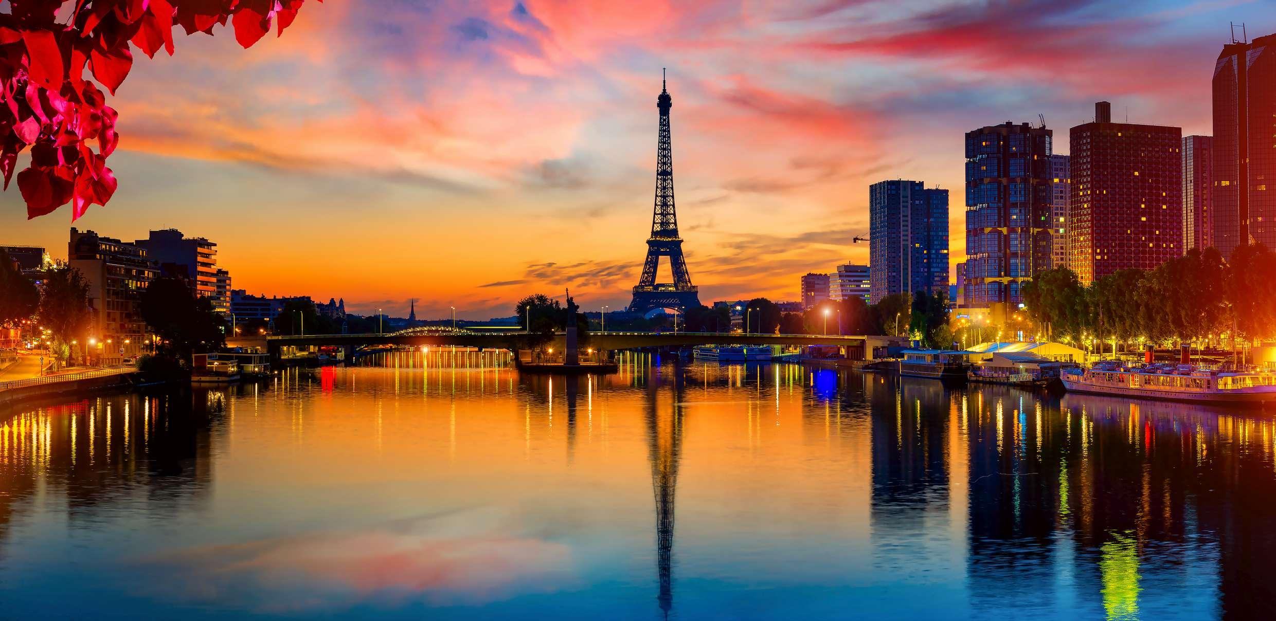 Blick auf den Eiffelturm und die Wolkenkratzer auf der Seine in Paris bei Nacht, Frankreich