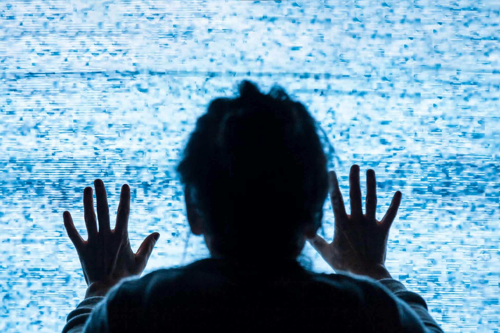 Traurige Frau mit ihren Händen auf dem Bildschirm Fernsehen ohne Signal - Krankheitskonzept