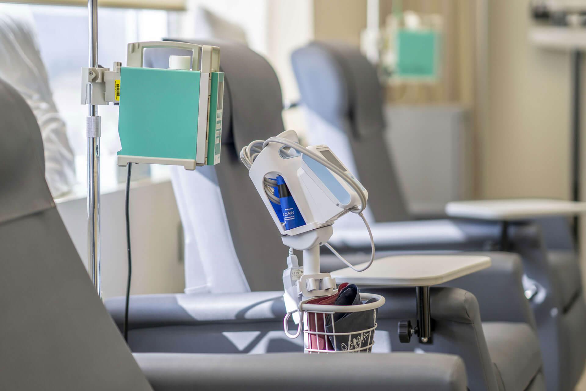 Ein Foto, das einen leeren Chemotherapie-Behandlungsraum zeigt. Der Raum verfügt über Sessel und medizinische Geräte und Zubehör.
