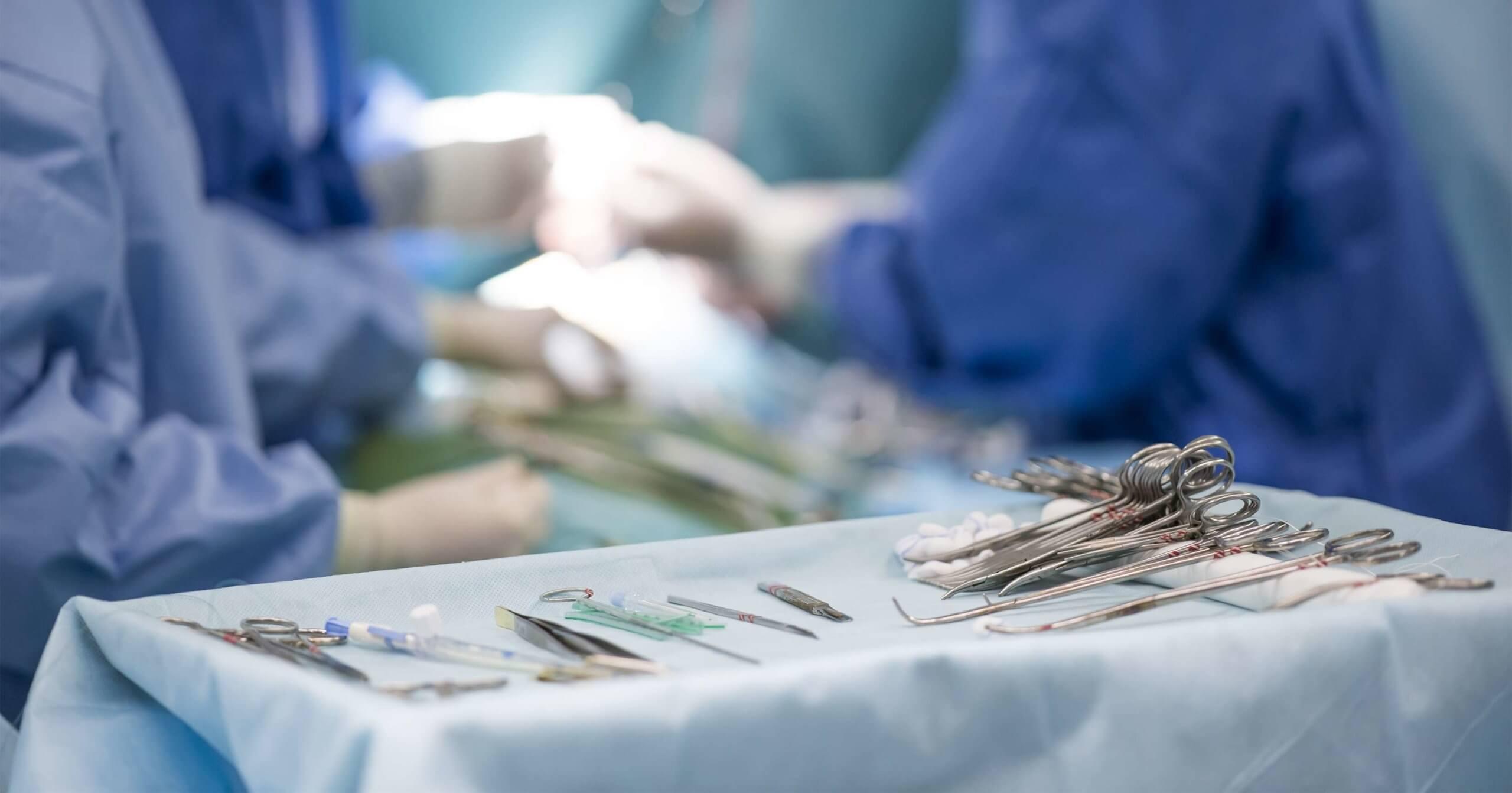 sterile chirurgische Instrumente auf dem Operationstisch inmitten der Chirurgen